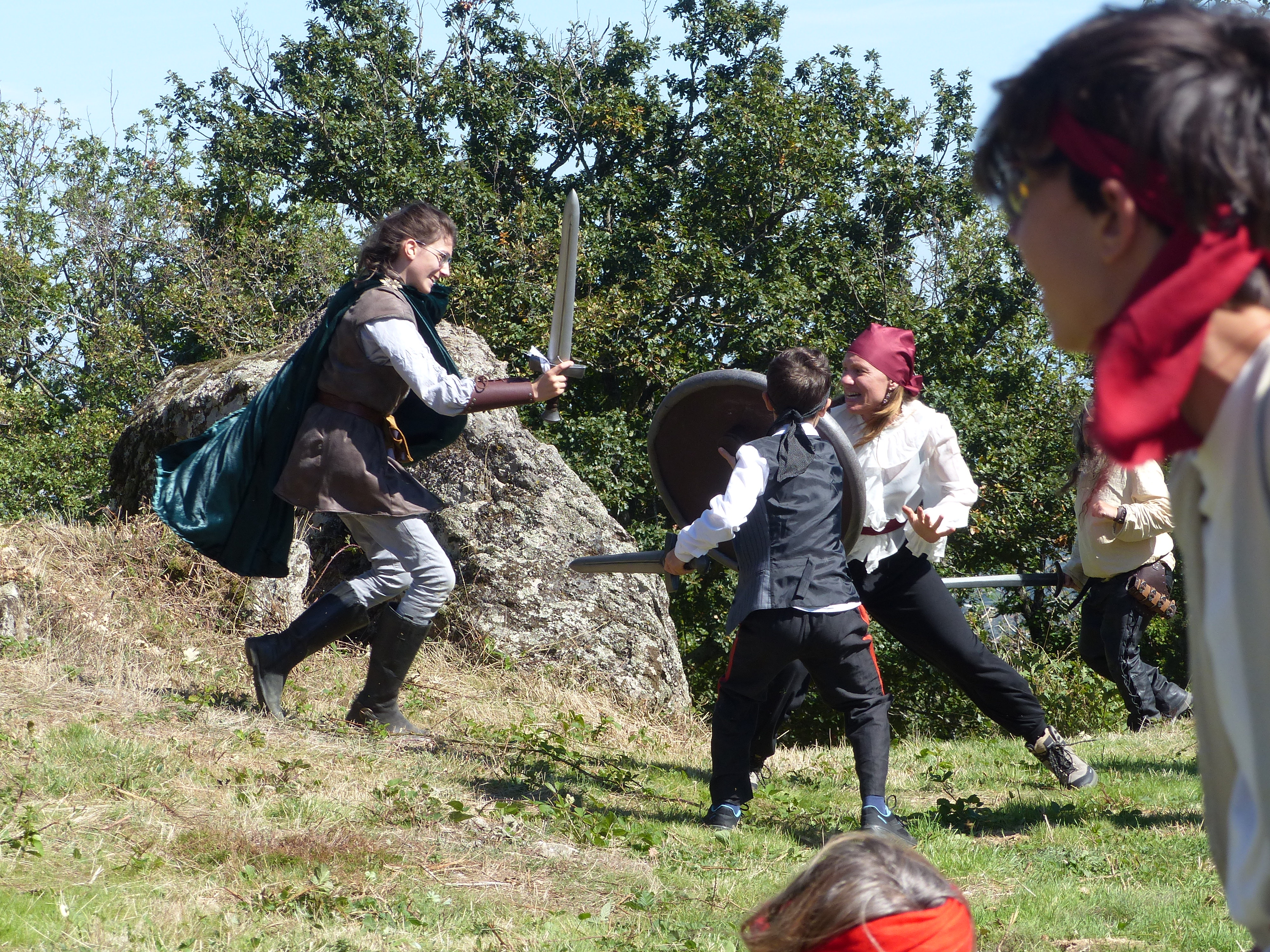 Duel à l'épée entre jeunes joueurs près du rocher